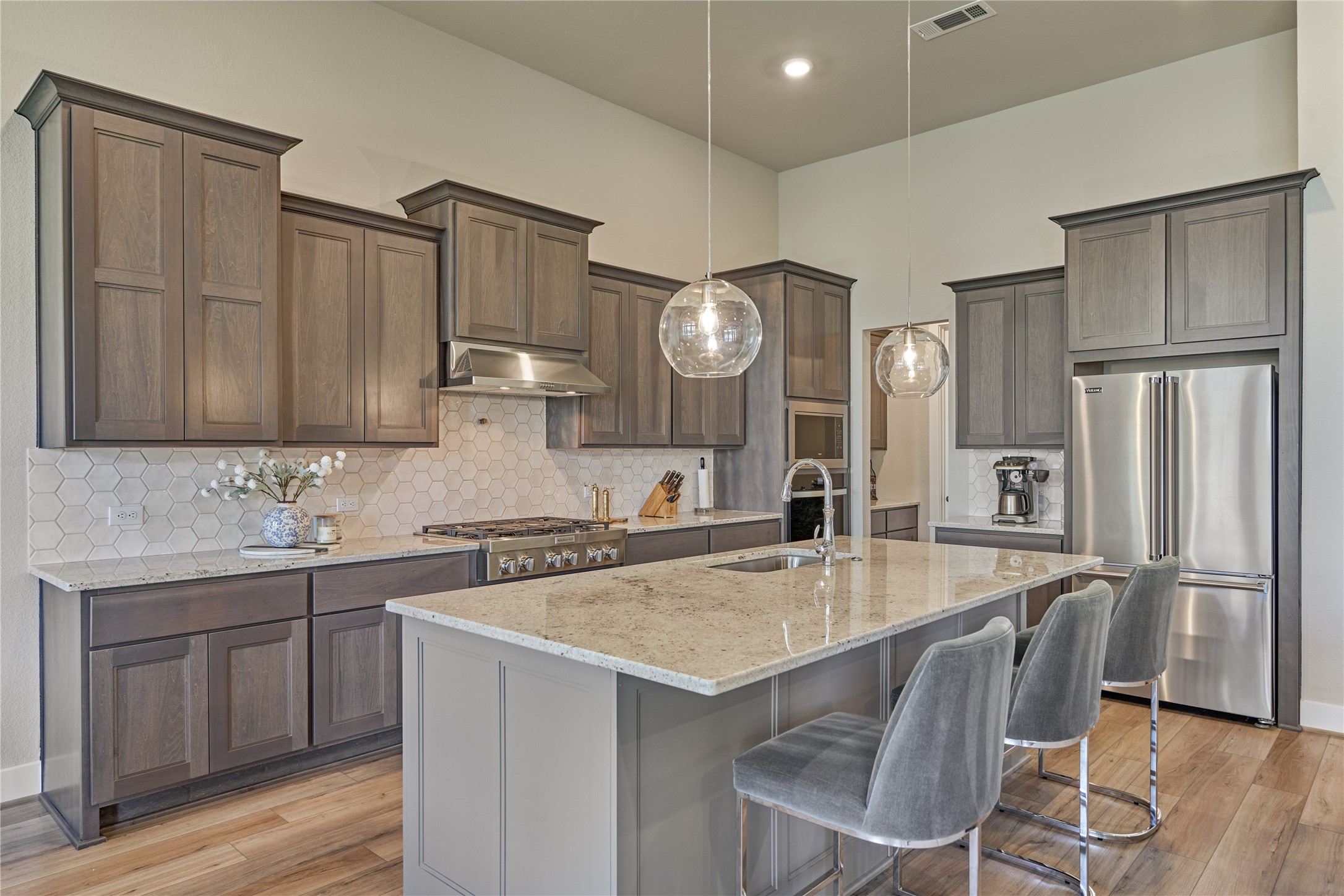1716 Encino Boulevard Conroe, TX 77304 - Photo 17 of 50 The sleek countertops and backsplash provide a luxurious contrast to the cabinetry that blends elegance with functionality.