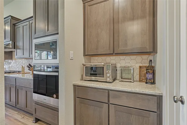 a kitchen with stainless steel appliances granite countertop a stove and a refrigerator with white cabinets