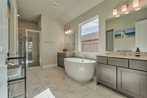 a spacious bathroom with a double vanity sink a mirror and a bathtub