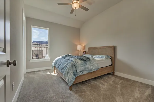 a spacious bedroom with a bed and a chandelier