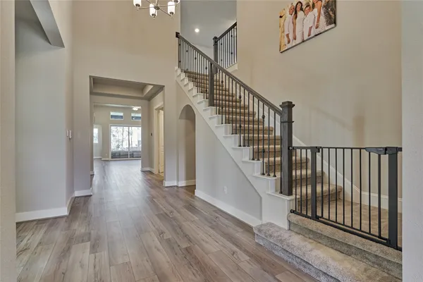 a view of a hallway with wooden floor and stairs