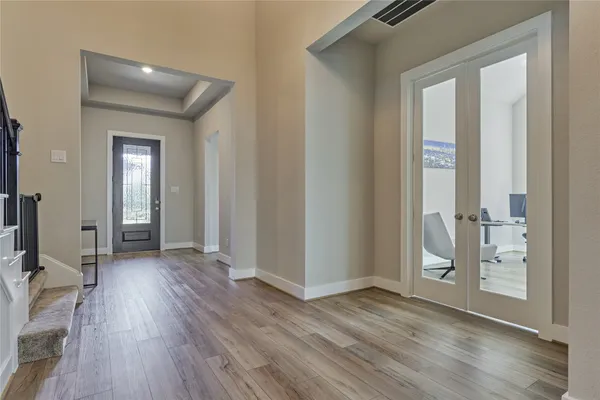 a view of a livingroom with wooden floor and a bathroom