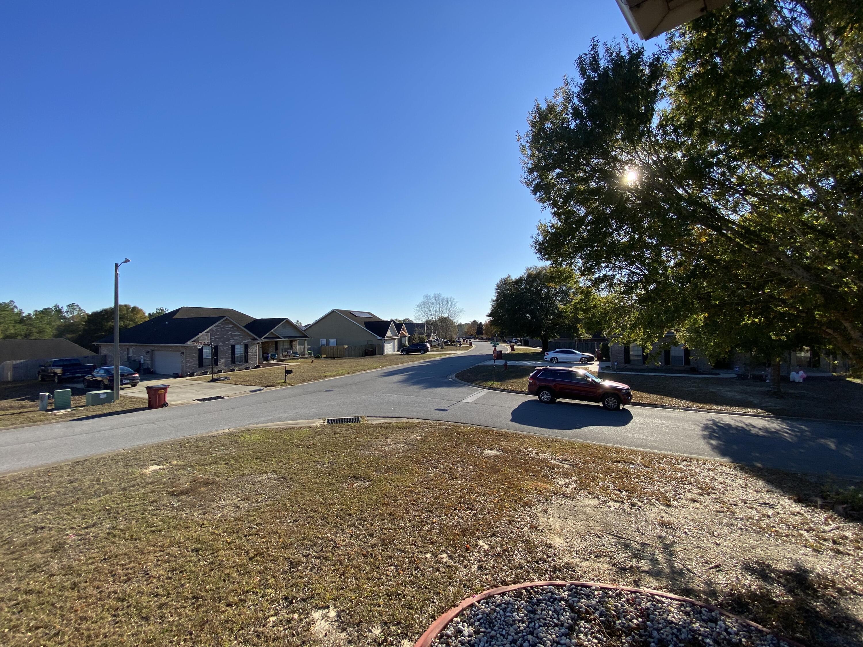 402 Wych Circle Crestview, FL 32536 - Photo 11 of 48 a view of a lake with a car parked on the side of the road