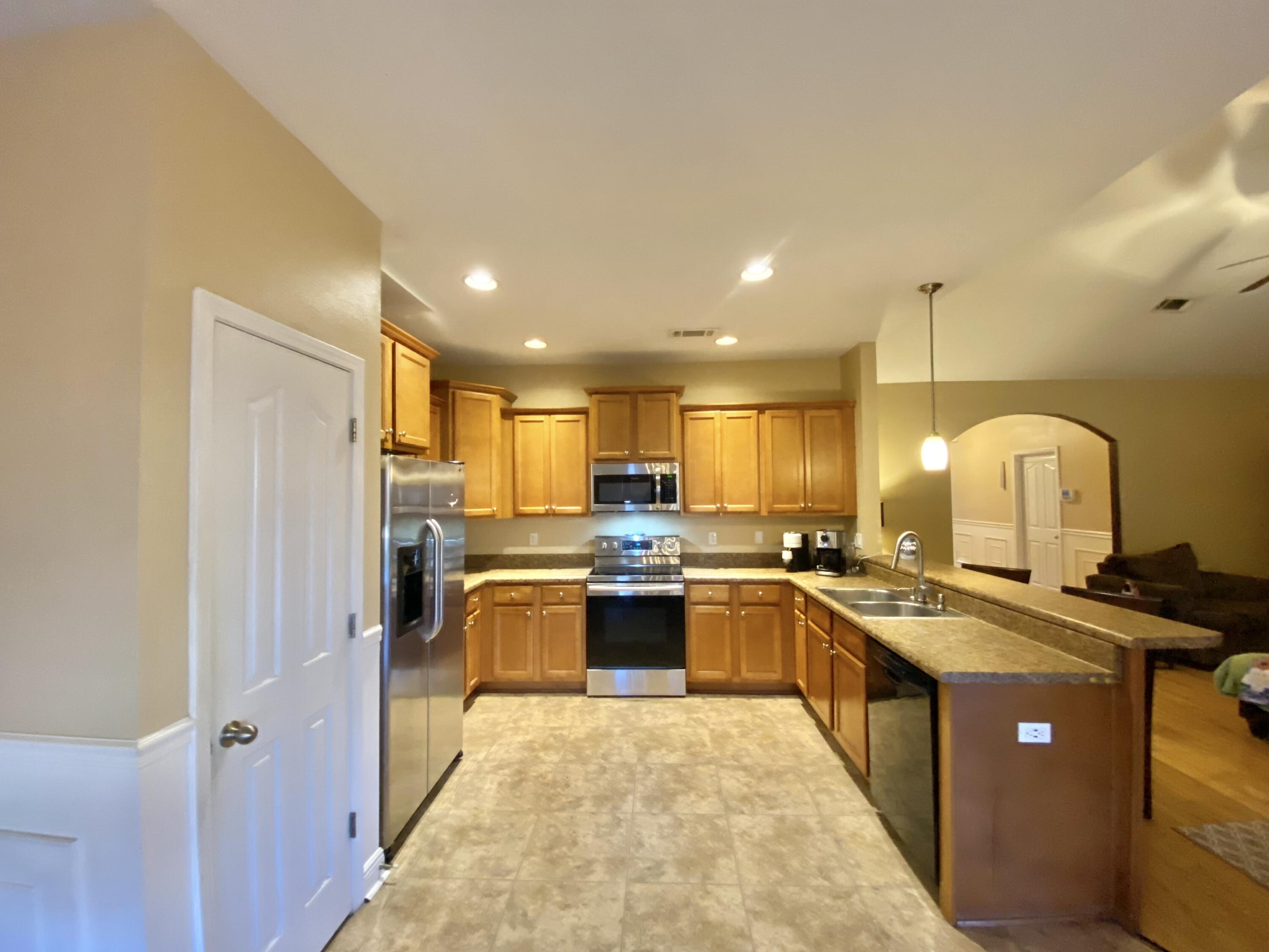 402 Wych Circle Crestview, FL 32536 - Photo 23 of 48 a kitchen with stainless steel appliances granite countertop a sink stove and refrigerator
