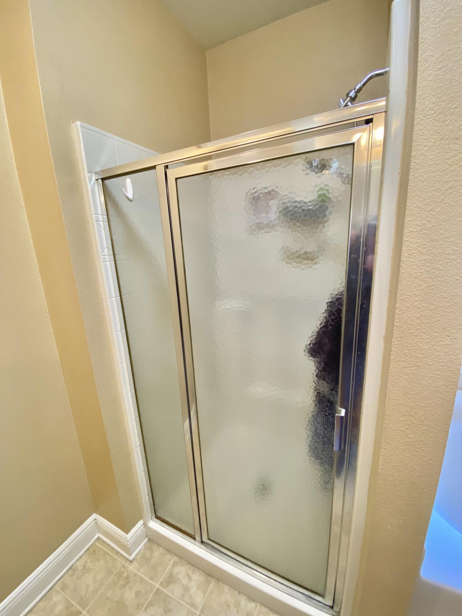 402 Wych Circle Crestview, FL 32536 - Photo 32 of 48 a bathroom with a glass shower door and mirror