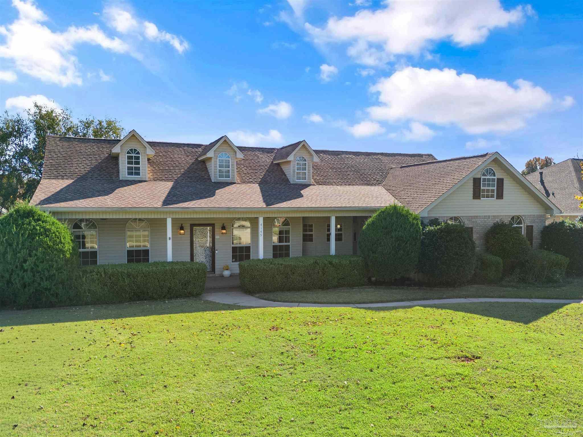 a front view of a house with a garden