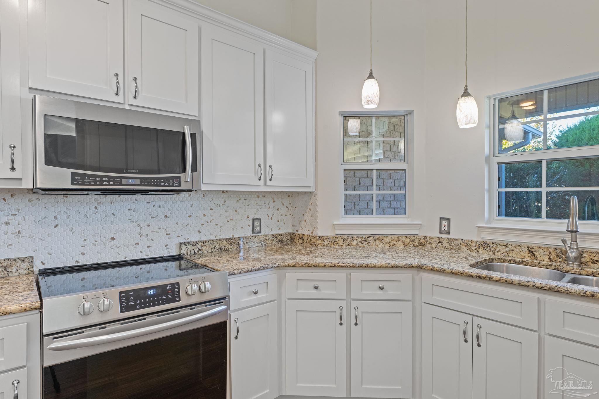 4149 Chartwell Street Pace, FL 32571 - Photo 14 of 49 a kitchen with granite countertop white cabinets and a stove