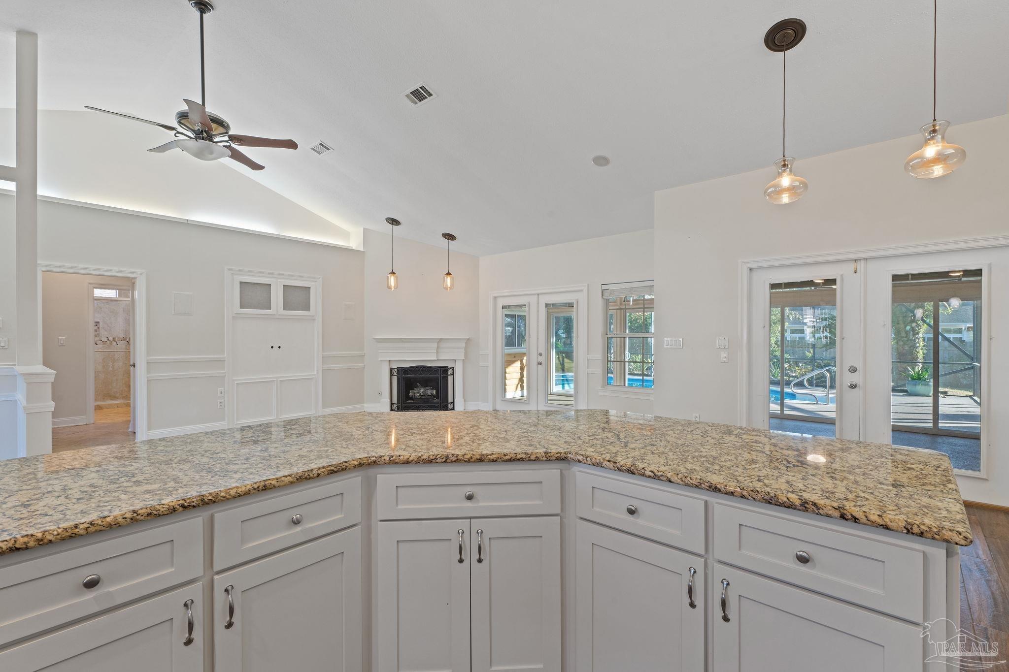 4149 Chartwell Street Pace, FL 32571 - Photo 15 of 49 a open kitchen with granite countertop white cabinets white countertops and granite countertops with wooden floor