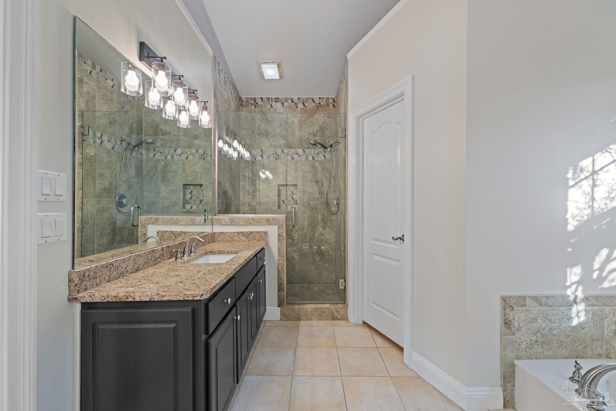 4149 Chartwell Street Pace, FL 32571 - Photo 24 of 49 a bathroom with a granite countertop sink a mirror and a shower