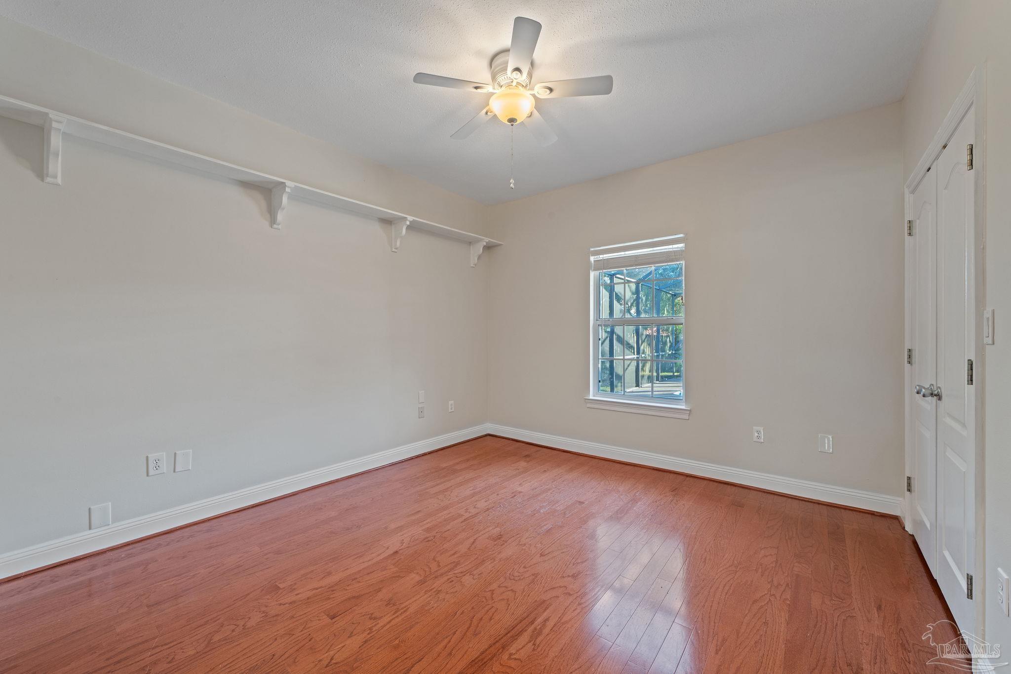 4149 Chartwell Street Pace, FL 32571 - Photo 28 of 49 a view of an empty room with a window and wooden floor