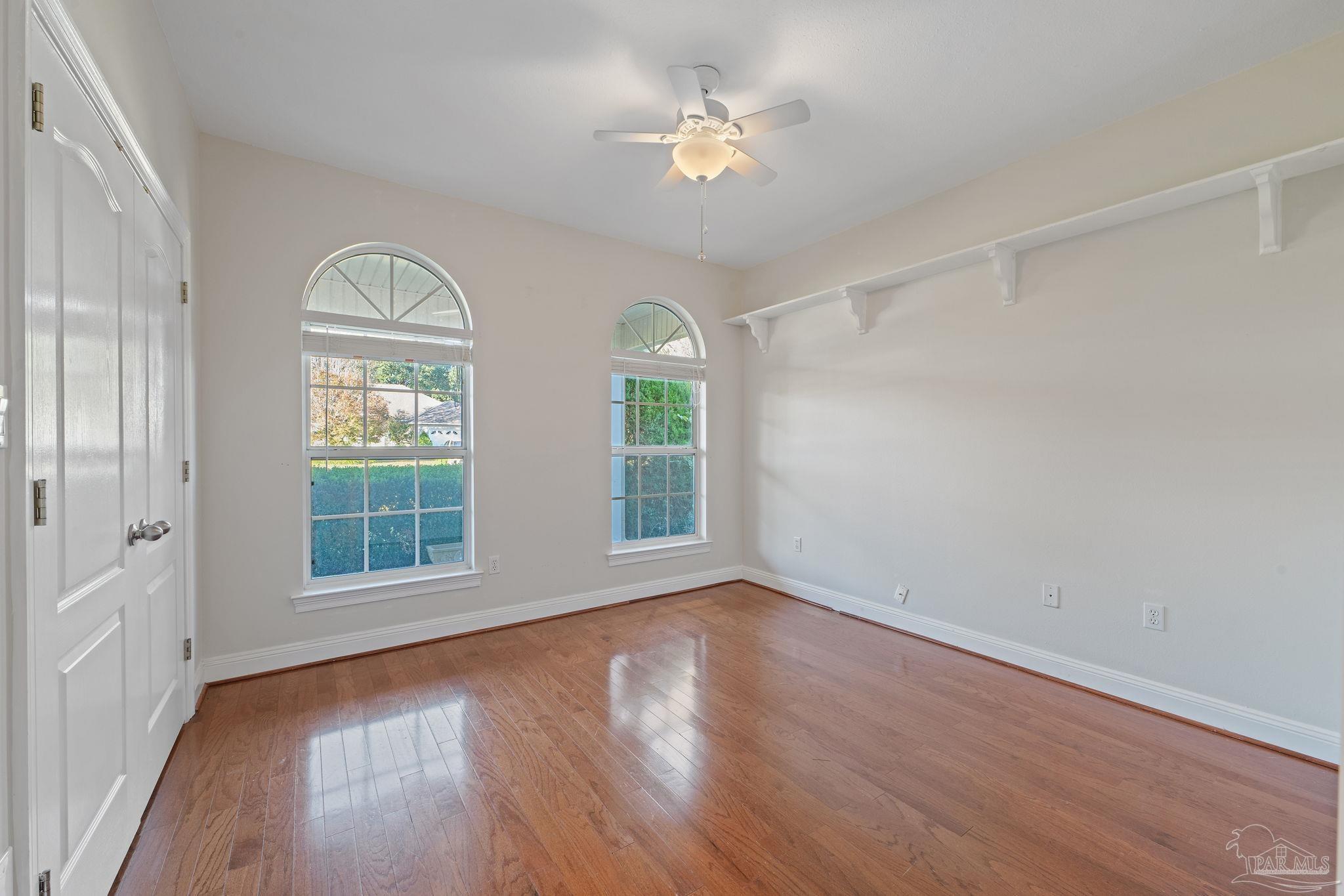 4149 Chartwell Street Pace, FL 32571 - Photo 30 of 49 an empty room with wooden floor chandelier fan and windows