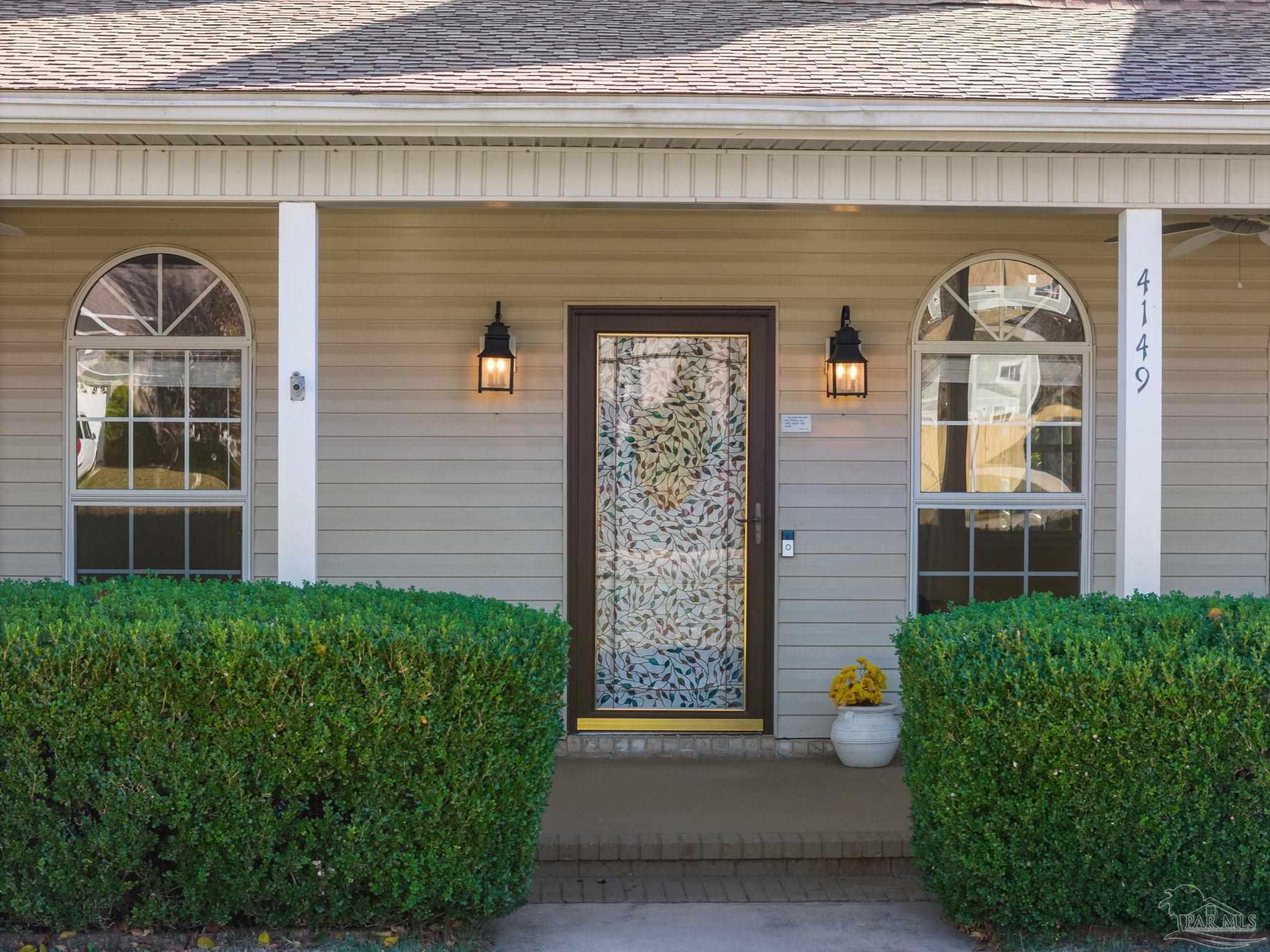 4149 Chartwell Street Pace, FL 32571 - Photo 3 of 49 a front view of a house with a garden