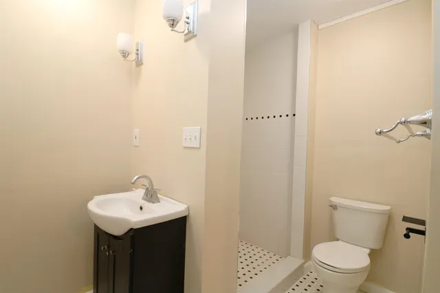 a bathroom with a sink a toilet and shower