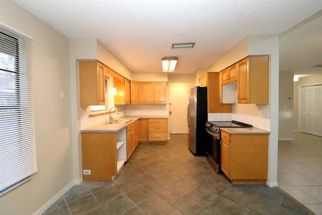 a kitchen with a stove a refrigerator and a sink