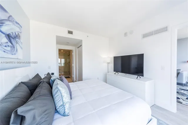 a bedroom with a bed and a flat screen tv