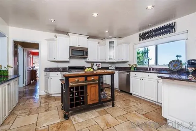 a kitchen with stainless steel appliances a stove sink and cabinets