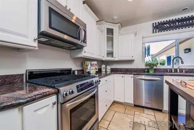 a kitchen with stainless steel appliances granite countertop a stove microwave and sink