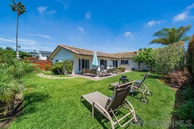 a view of a house with backyard sitting area and garden