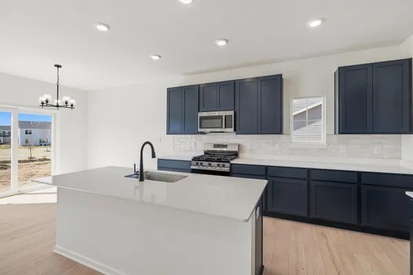 a kitchen with stainless steel appliances a sink stove and cabinets