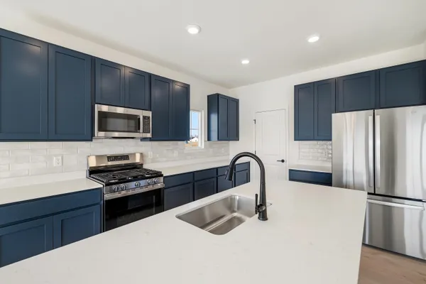 a kitchen with stainless steel appliances a refrigerator stove microwave and cabinets