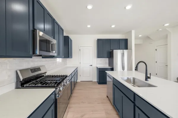 a kitchen with stainless steel appliances a sink stove and refrigerator