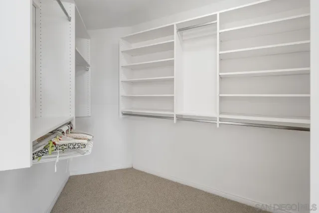 a view of walk in closet with empty racks