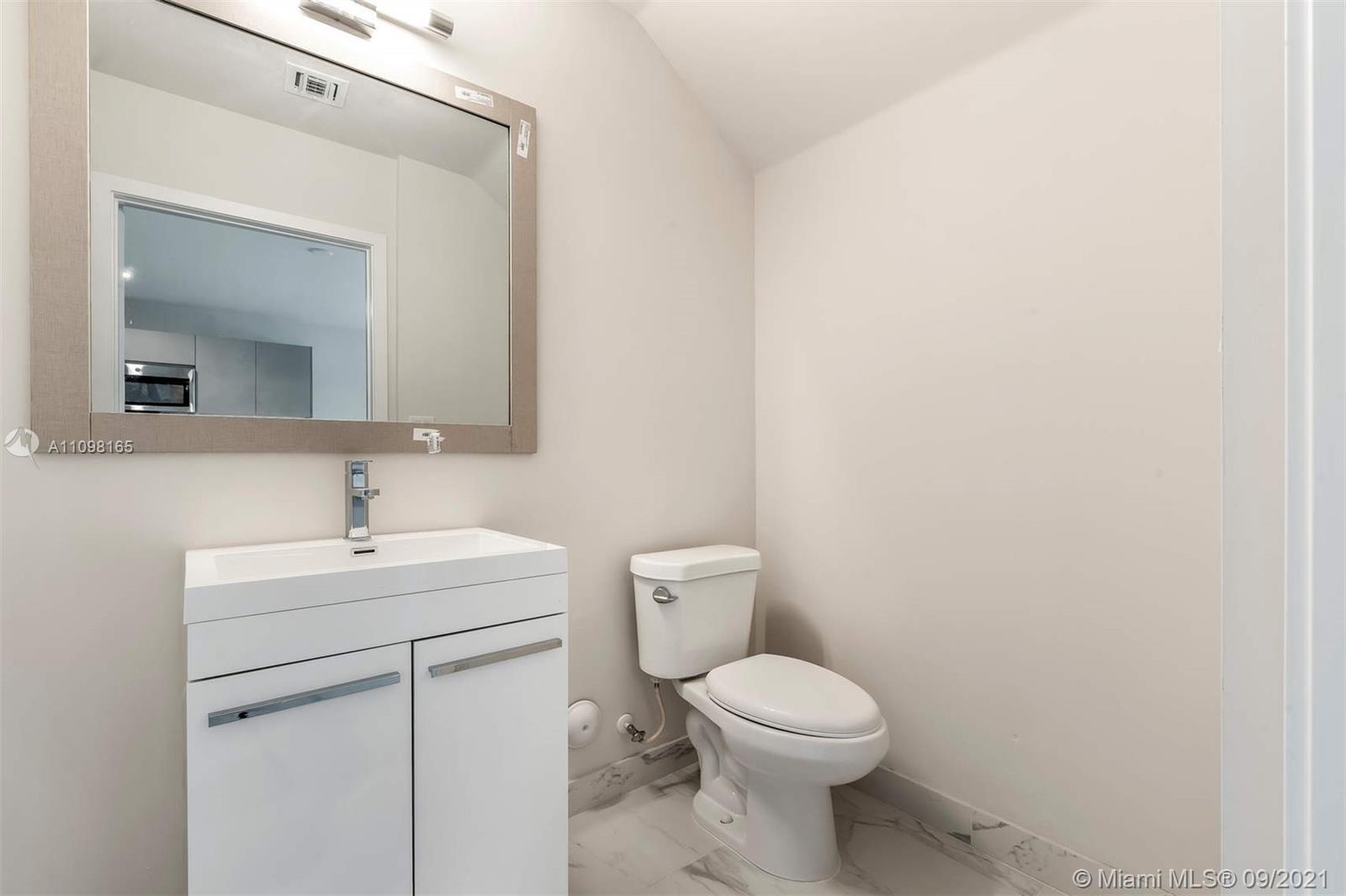 Ojus Miami, FL 33180 - Photo 15 of 17 a bathroom with a toilet a sink and mirror