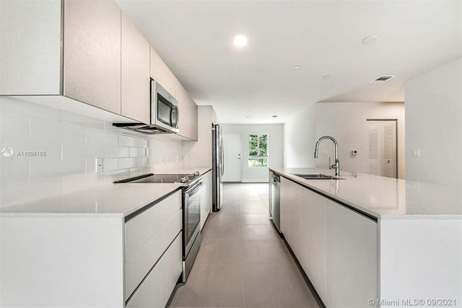 Ojus Miami, FL 33180 - Photo 6 of 17 a kitchen with stainless steel appliances granite countertop a sink and dishwasher a stove top oven with wooden floor