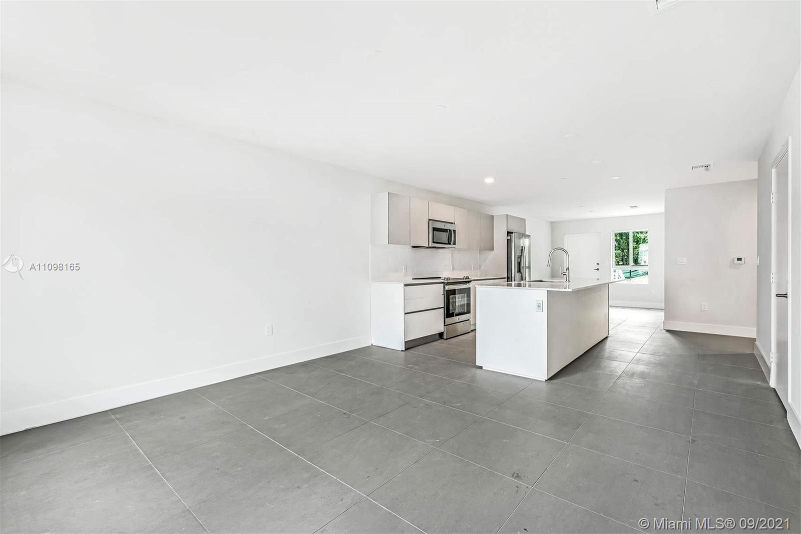 Ojus Miami, FL 33180 - Photo 9 of 17 a view of kitchen with kitchen island microwave and cabinets