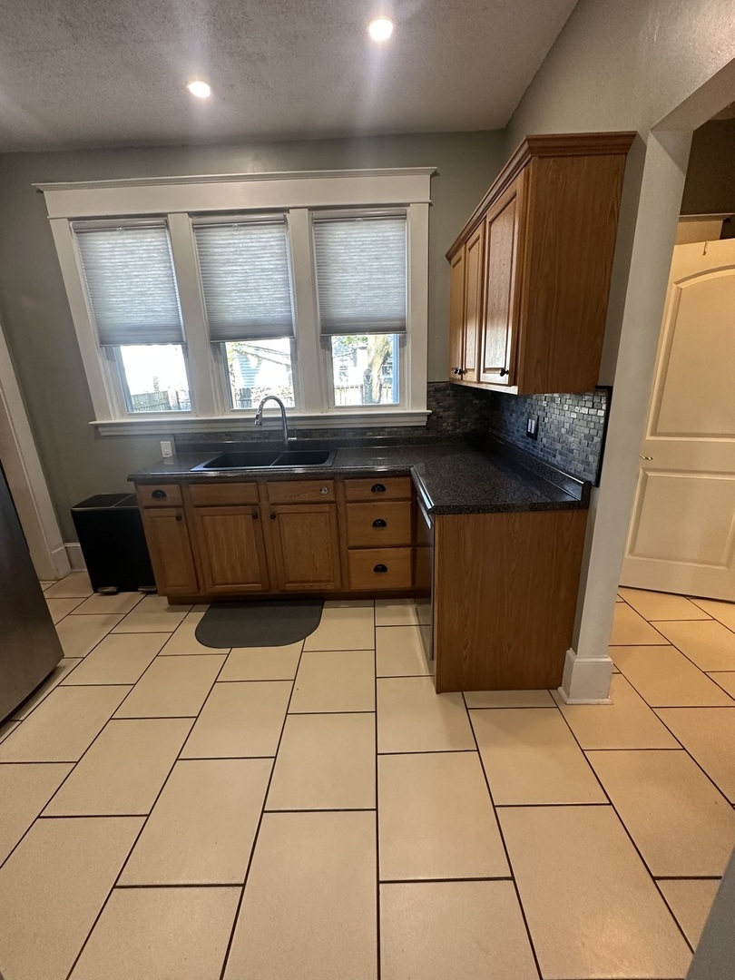 1307 South Main Street Bloomington, IL 61701 - Photo 23 of 48 a kitchen with granite countertop a stove a sink a counter top space and cabinets