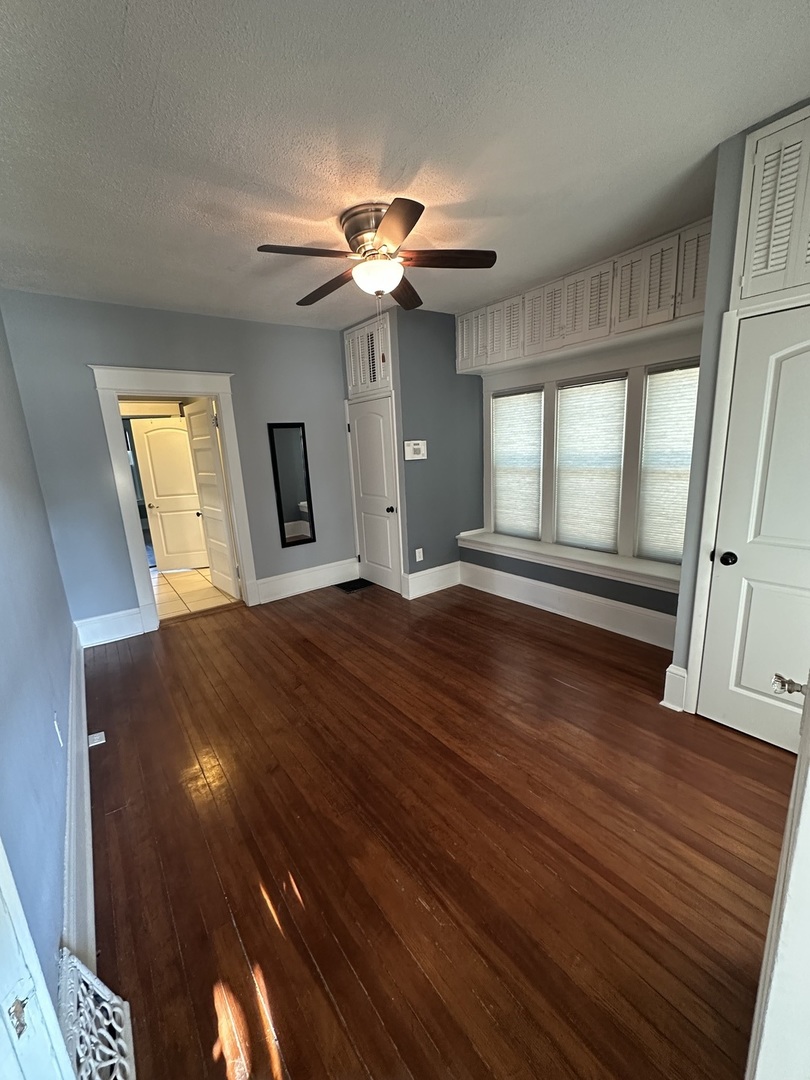 1307 South Main Street Bloomington, IL 61701 - Photo 38 of 48 a view of an empty room with window and wooden floor