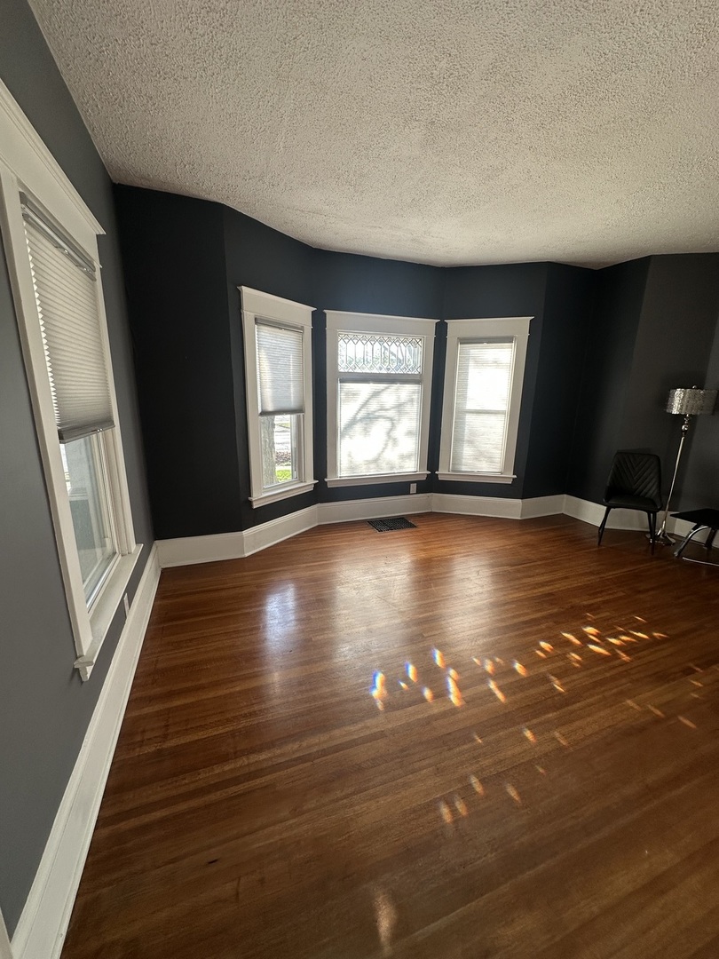 1307 South Main Street Bloomington, IL 61701 - Photo 9 of 48 a view of an empty room with wooden floor and a window