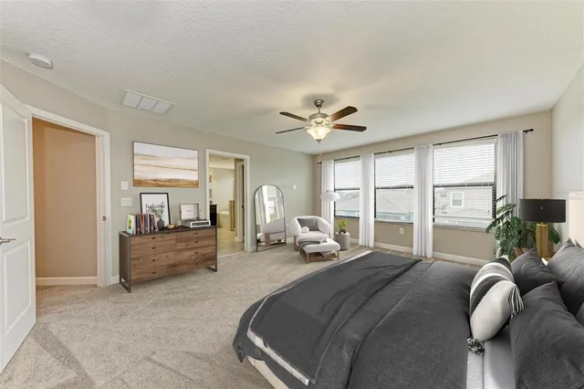 a large bedroom with a large bed and windows