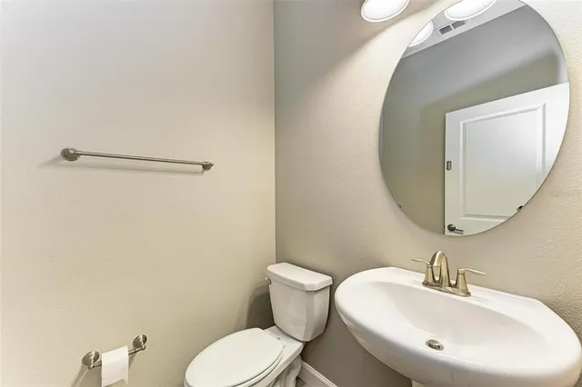 a bathroom with a toilet a sink and mirror
