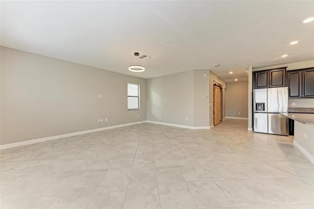 a view of an empty room with a kitchen