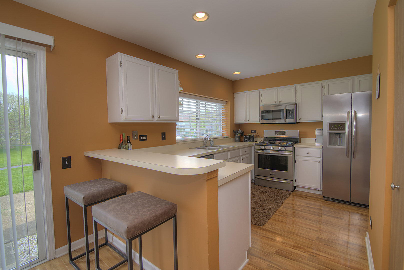 33 North Oltendorf Road Streamwood, IL 60107 - Photo 7 of 23 a kitchen with kitchen island granite countertop wooden cabinets a sink a stove a refrigerator and island with wooden floor