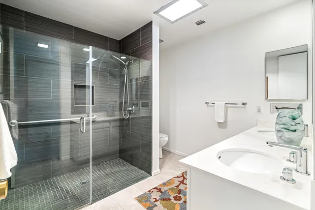 a bathroom with a sink a toilet and shower