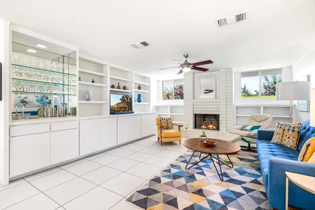 a living room with furniture large window and a fireplace