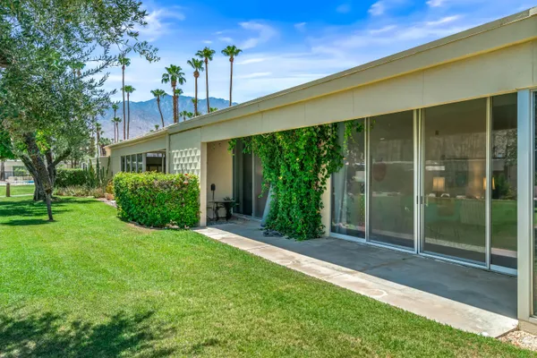 a view of a swimming pool with a yard and plants