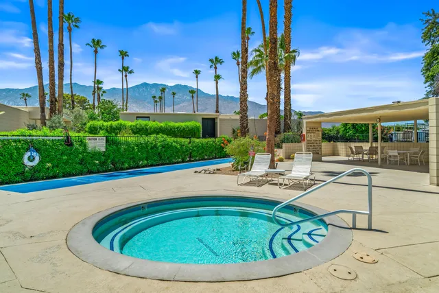 a view of a swimming pool with an outdoor seating and house in the background