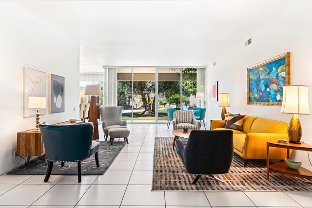 a living room with furniture a lamp and a large window