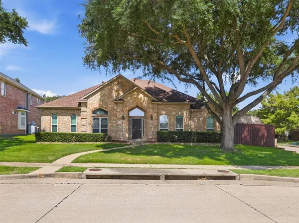 a view of a house with a big yard plants and large trees