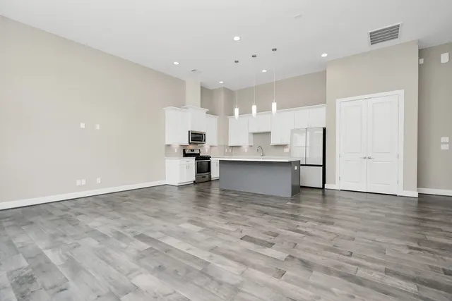 a view of kitchen with kitchen island white cabinets and refrigerator