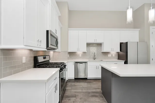 a kitchen with a sink stove and white cabinets