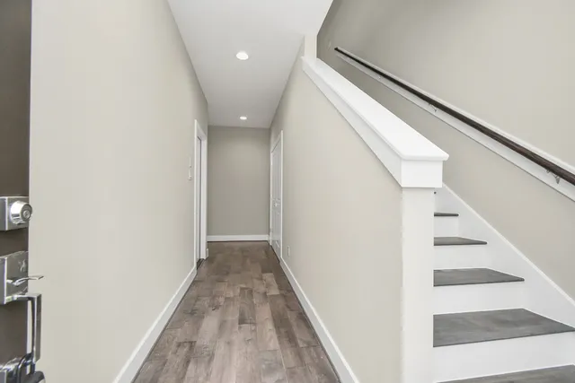 a view of a hallway with wooden floor and staircase