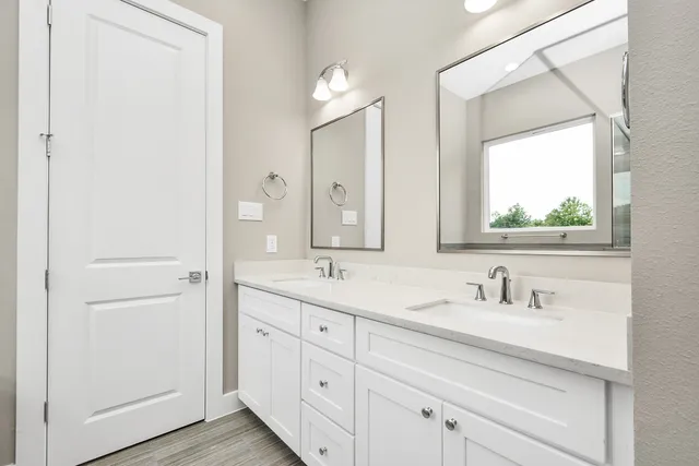 a bathroom with a double vanity sink mirror and