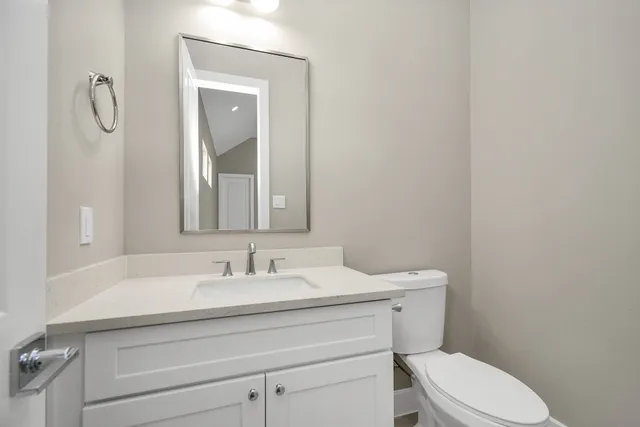 a bathroom with a sink toilet and mirror