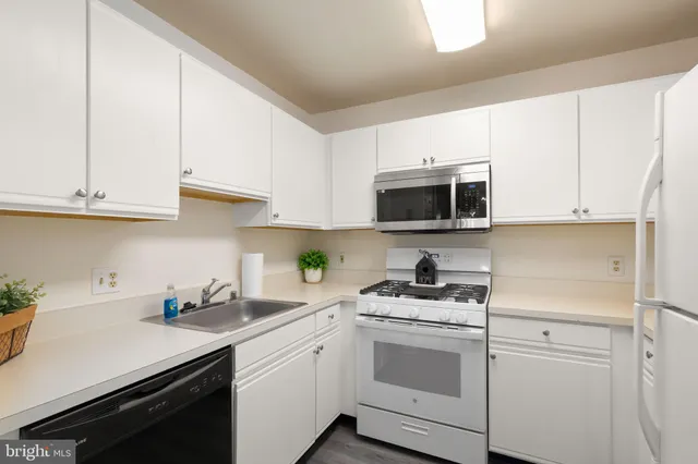 a kitchen with stainless steel appliances granite countertop white cabinets sink and stove