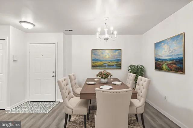 a dining room with furniture a chandelier and wooden floor
