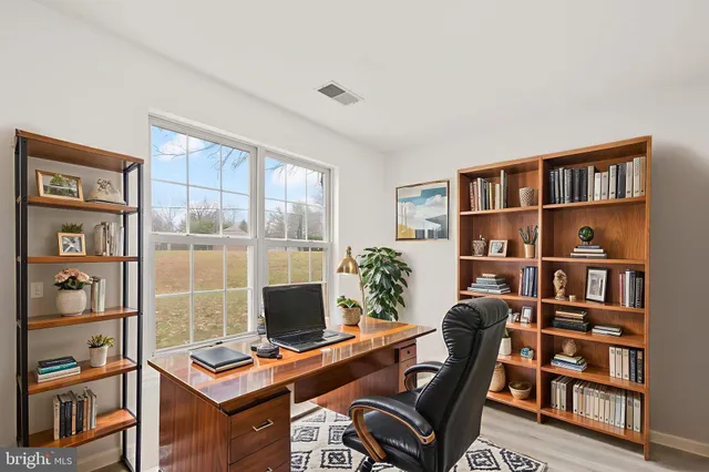 a view of a workspace with furniture and a book shelf